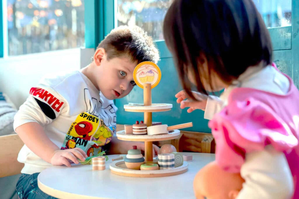 Two children playing afternoon tea in a childcare center